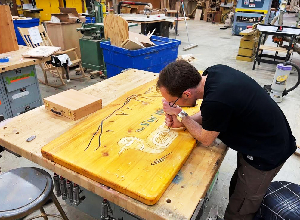 Will Peterson Carving Sus Heeni Shaak Community sign